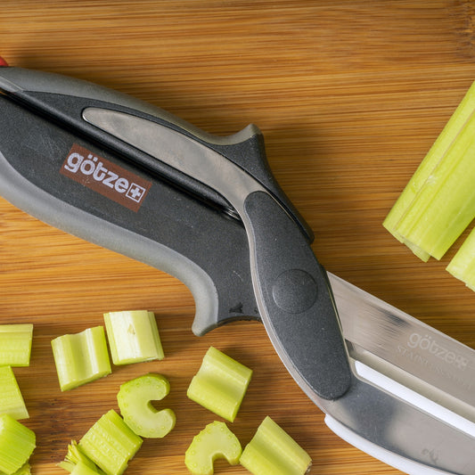 Set of kitchen tools including a peeler, mandoline, and other cutting tools with sliced vegetables on a white background.