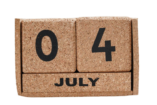 Cork calendar block displaying '07 4 JULY' on a white background
