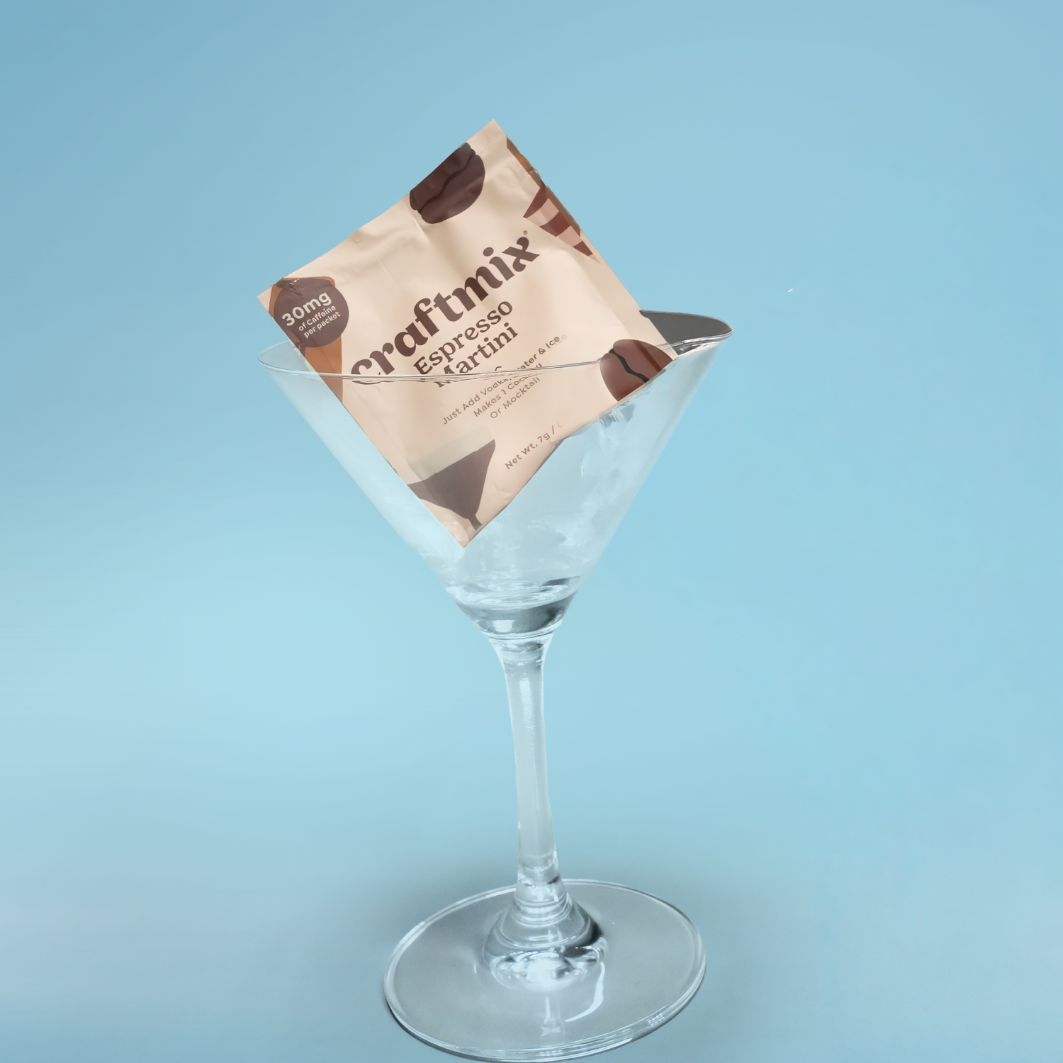 Craftmix Espresso Martini mix packet in a martini glass on a light blue background