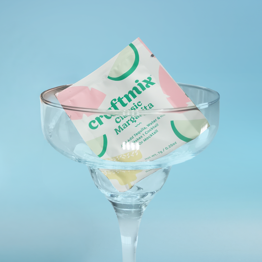 Cointreau Craftmix Classic Margarita mix packet in a clear glass against a light blue background
