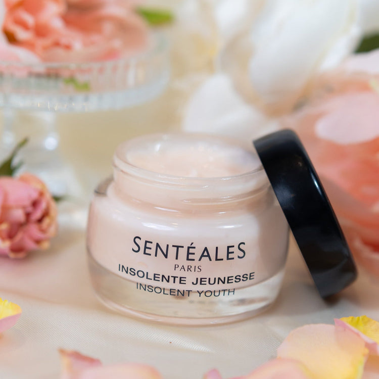 Skincare jar with 'Sentéales Paris' on a floral background