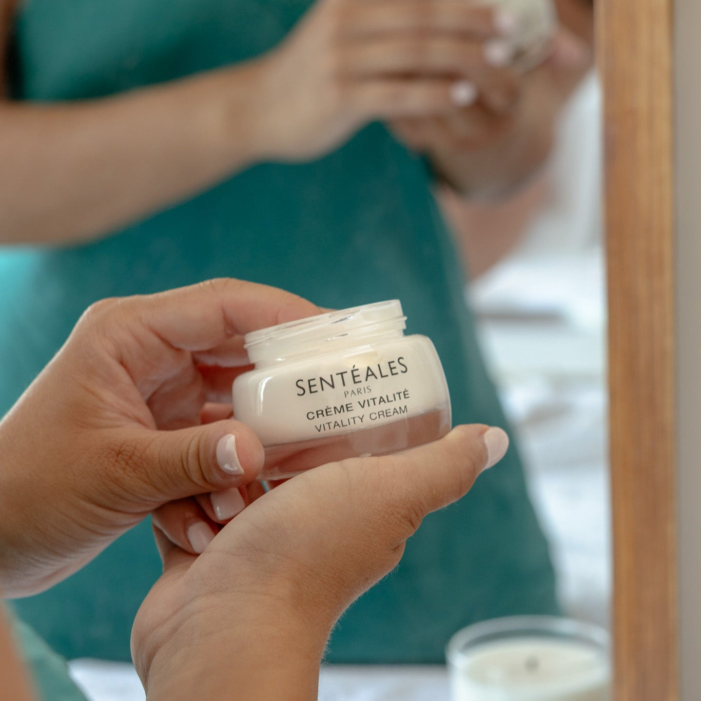 Person holding a jar of Sentéales Crème Vitalité with a blurred background
