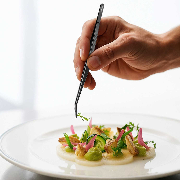 Hand using tweezers to place a garnish on a dish of food