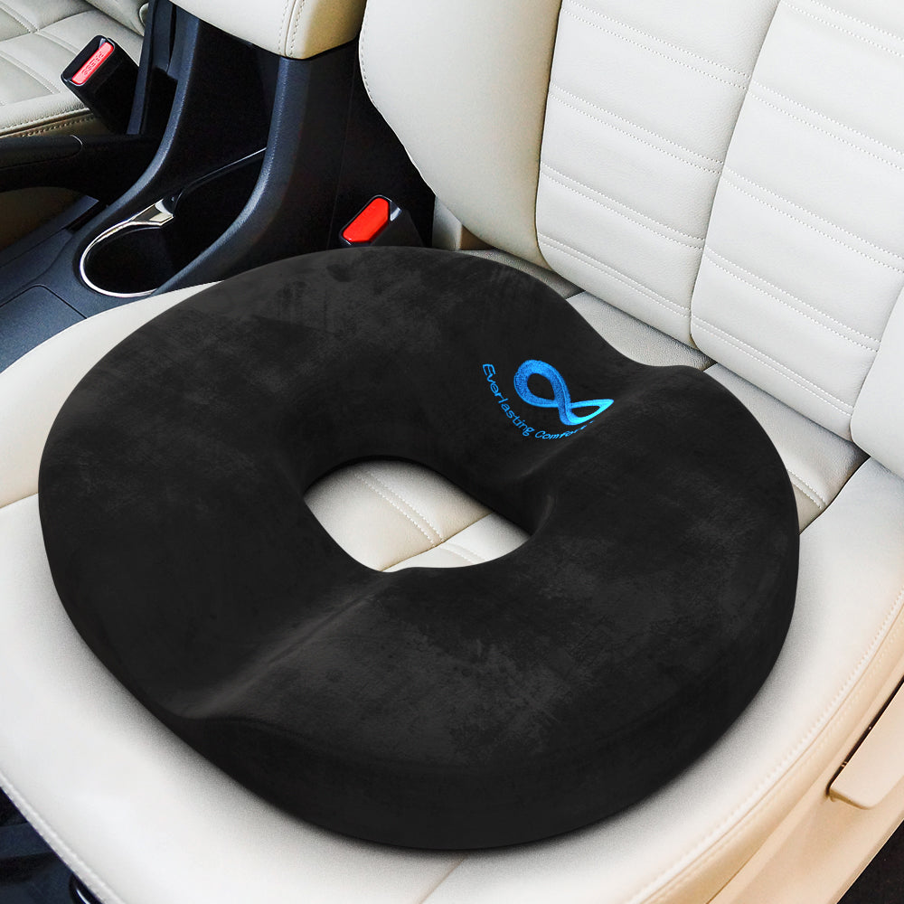Black donut seat cushion on a car seat with visible brand logo.