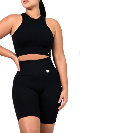 Black athletic outfit with a crop top and high-waisted shorts on a white background