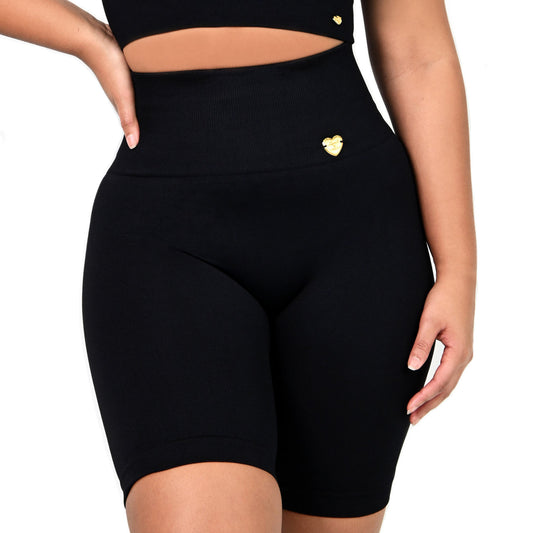 Black athletic outfit with a crop top and high-waisted shorts on a white background