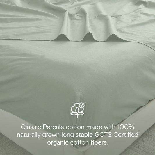 Green bedspread set on a bed in a bright bedroom with decor elements.