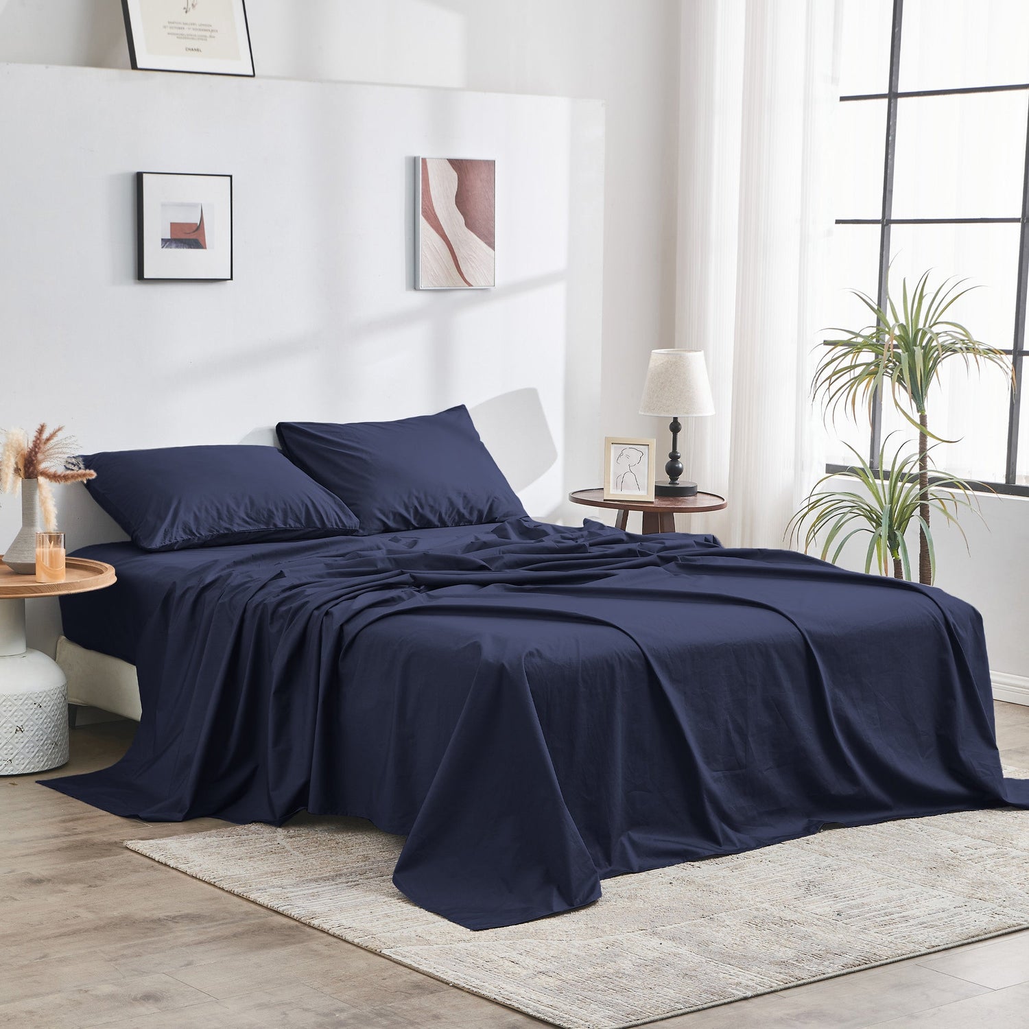 Navy blue bedding set on a bed in a modern bedroom with decor elements.