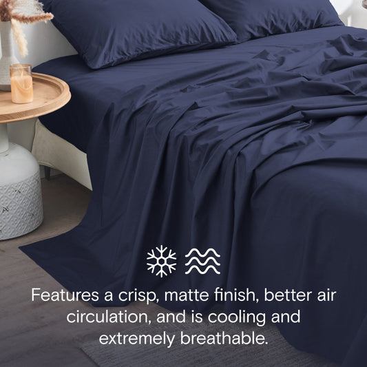 Navy blue bedding set on a bed in a modern bedroom with decor elements.