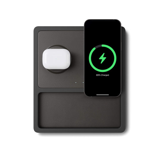 A wireless charging pad with two charging coils and separate charging ports for USB-C and USB-A, with an iPhone and AirPods on it indicating the MagSafe technology.