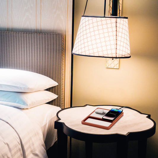 A wireless charging pad with a compartment for charging AirPods or small devices, and another for a smartphone, with a smartphone on top indicating charging status.