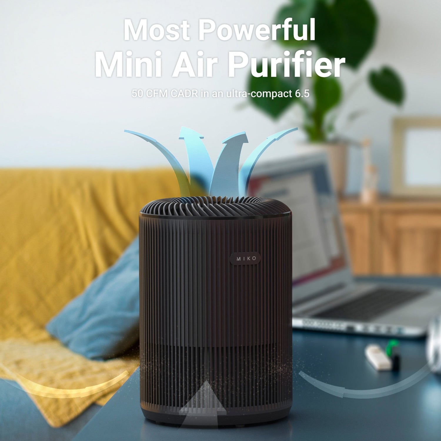 Mini air purifier on a table with a laptop and plant in the background