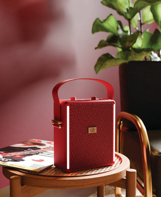 Red portable speaker with textured gold side on a white background
