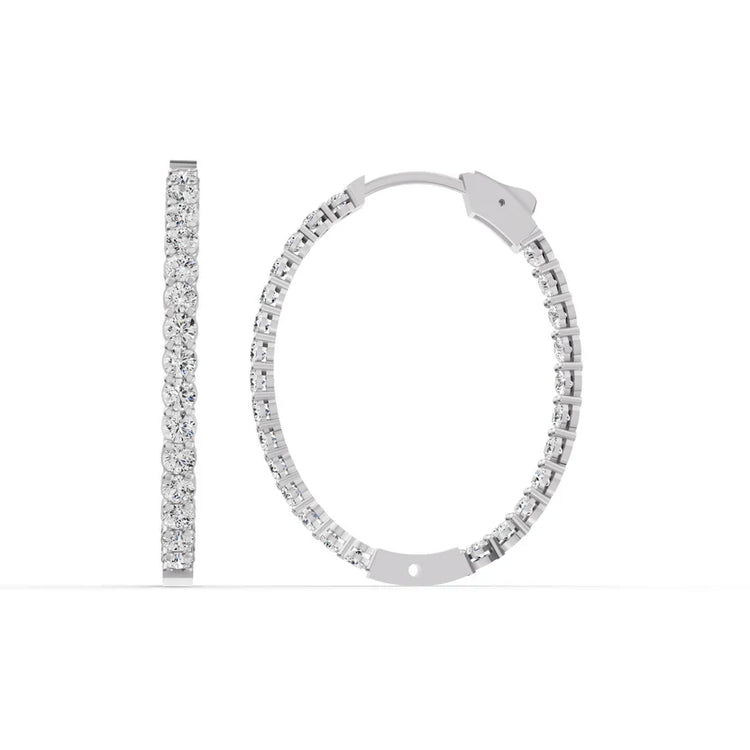Silver hoop earrings with clear gemstones on a white background