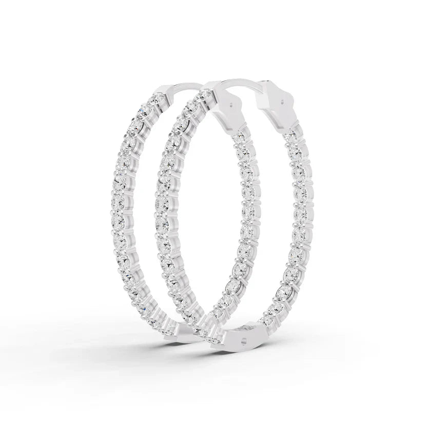 Pair of silver hoop earrings with clear gemstones on a white background