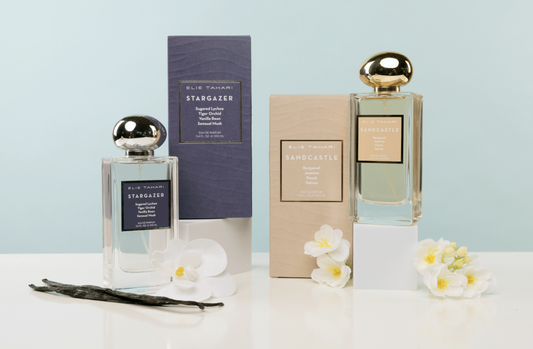 Two perfume bottles with their packaging on a light blue background