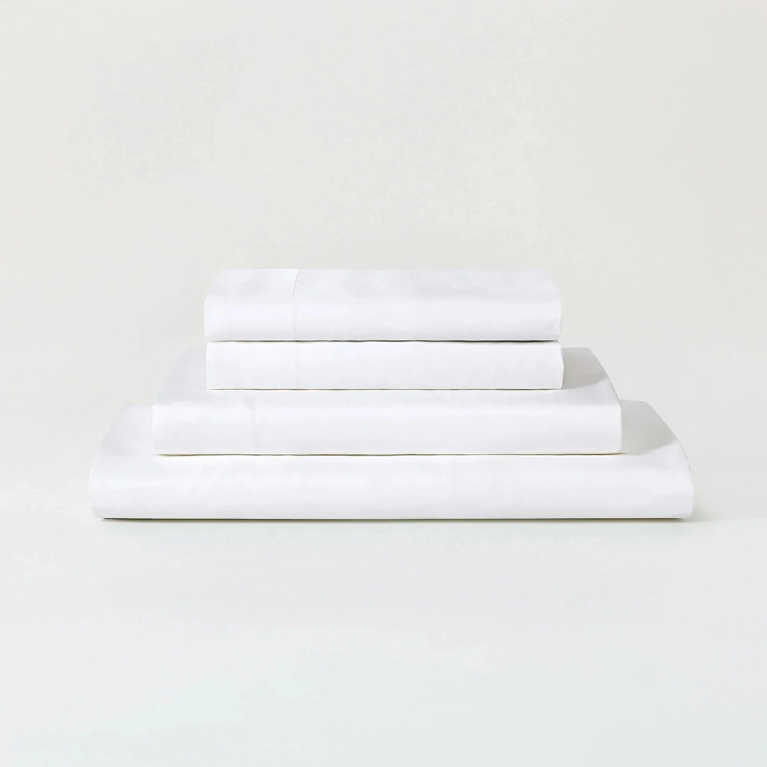 Stack of white folded towels on a light gray background