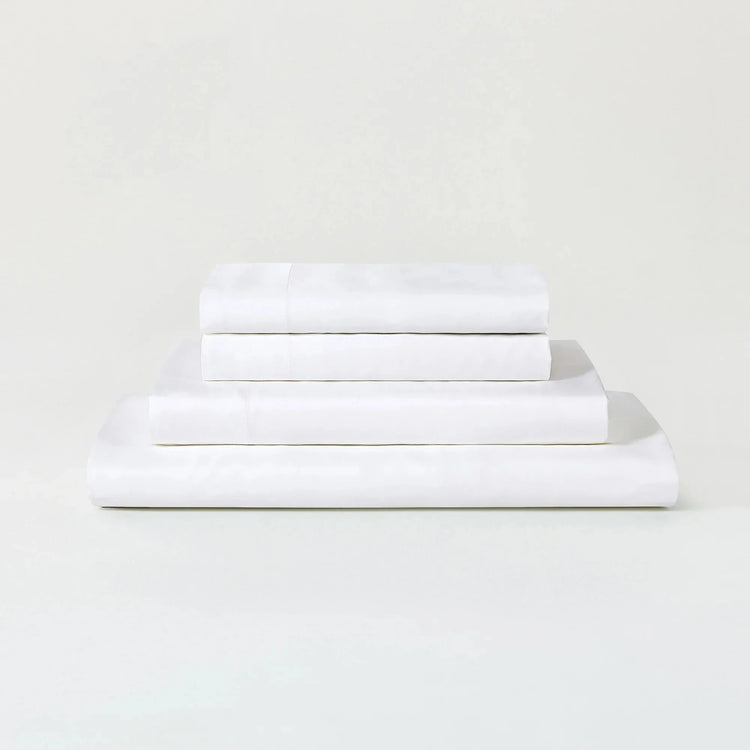 Stack of white folded towels on a light gray background