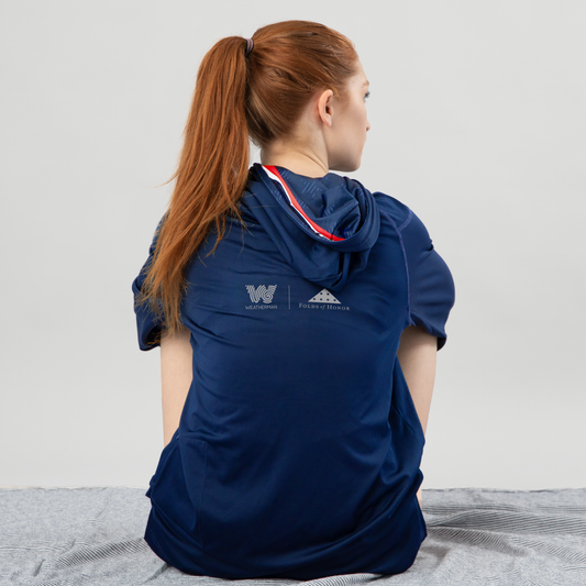 Woman sitting and wearing Folds of Honor Sun Shirt.