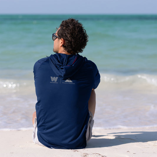 Woman sitting and wearing Folds of Honor Sun Shirt.