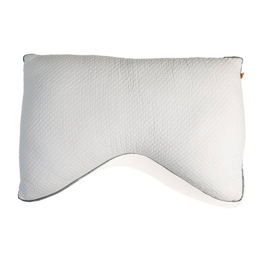A white, rectangular side sleeper pillow with a pillowcase on a bed, against a wooden headboard background.