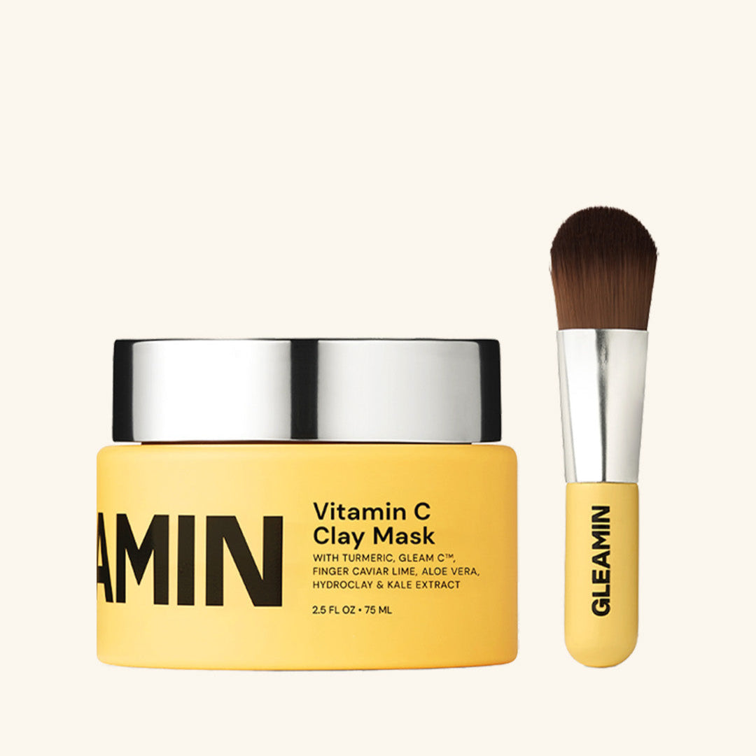 Yellow vitamin C clay mask with silver cap and brush on a white background