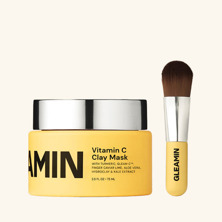 Yellow vitamin C clay mask with silver cap and brush on a white background