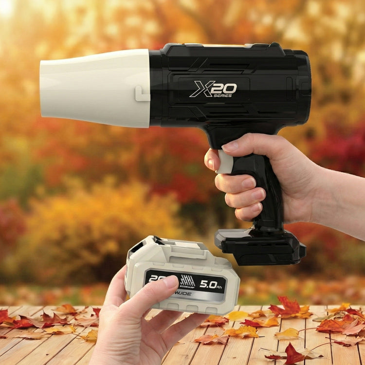 Handheld power tool with 'X20' branding held by a person against an autumn background.