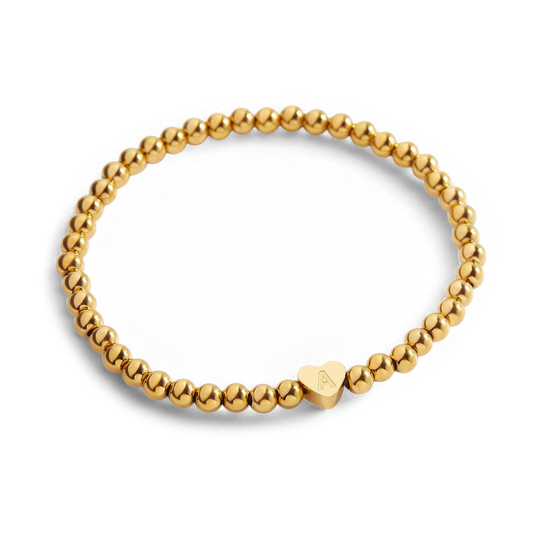 Gold beaded bracelet with a heart-shaped clasp on a white background
