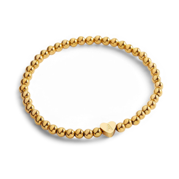 Gold beaded bracelet with a heart-shaped clasp on a white background