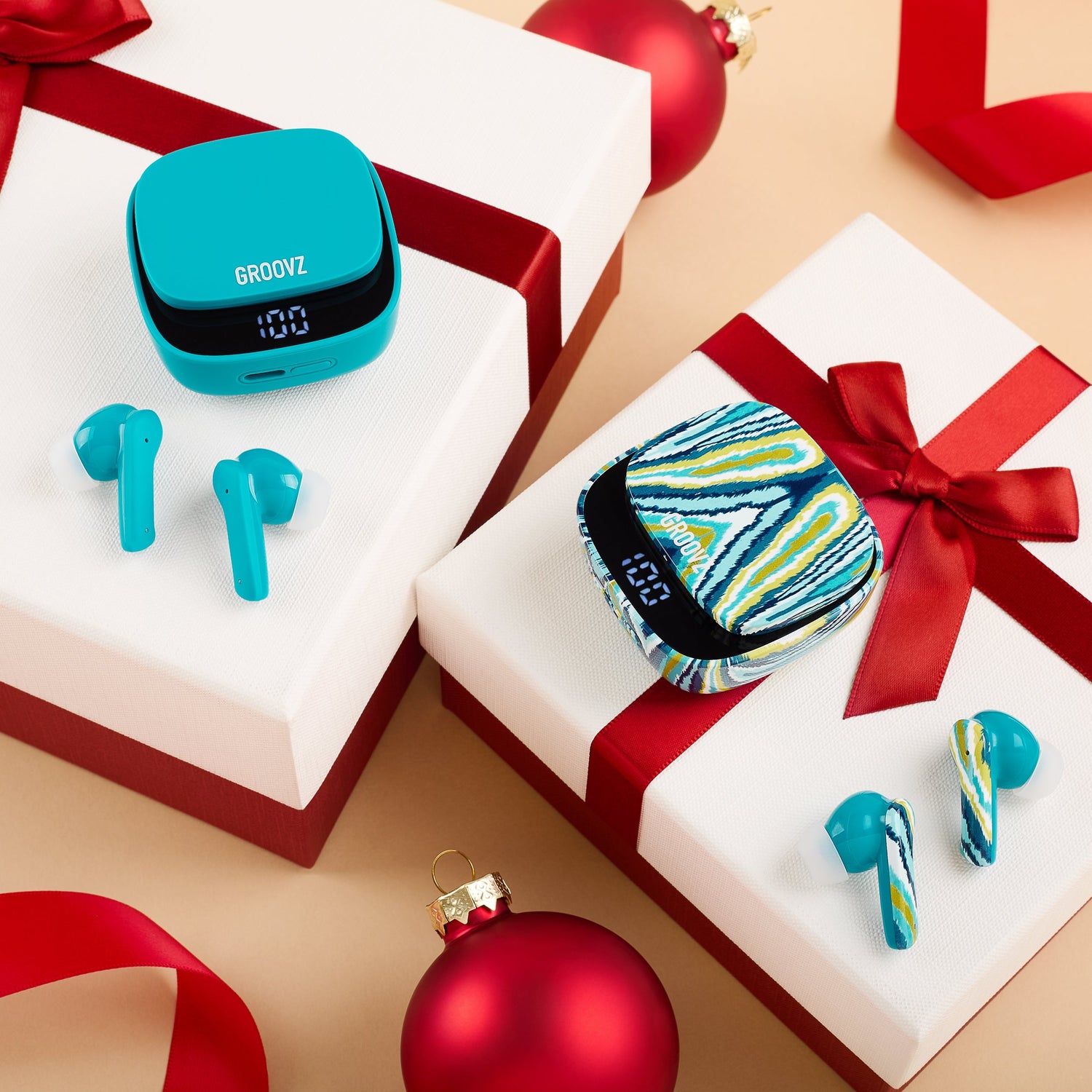 Blue wireless earbuds with a matching case on gift boxes with red ribbons and ornaments.