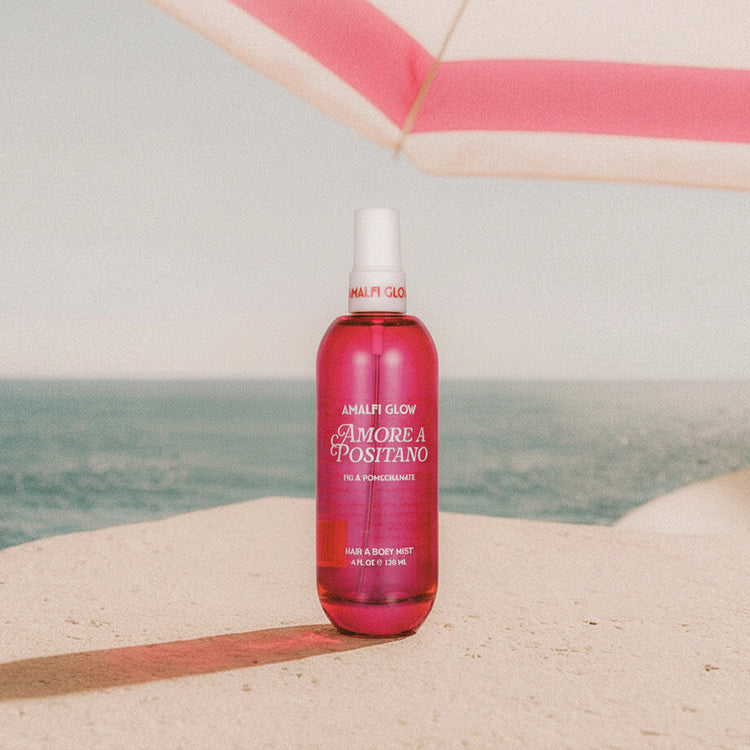 Pink bottle of 'Amore a Positano' on a beach with ocean view