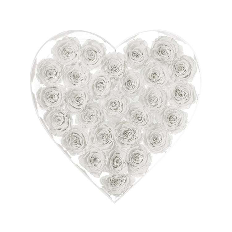 Heart-shaped arrangement of white roses in a clear box on a white background