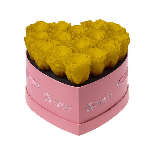 Heart-shaped box with yellow roses and pink base, featuring 'Speaking Roses' branding.