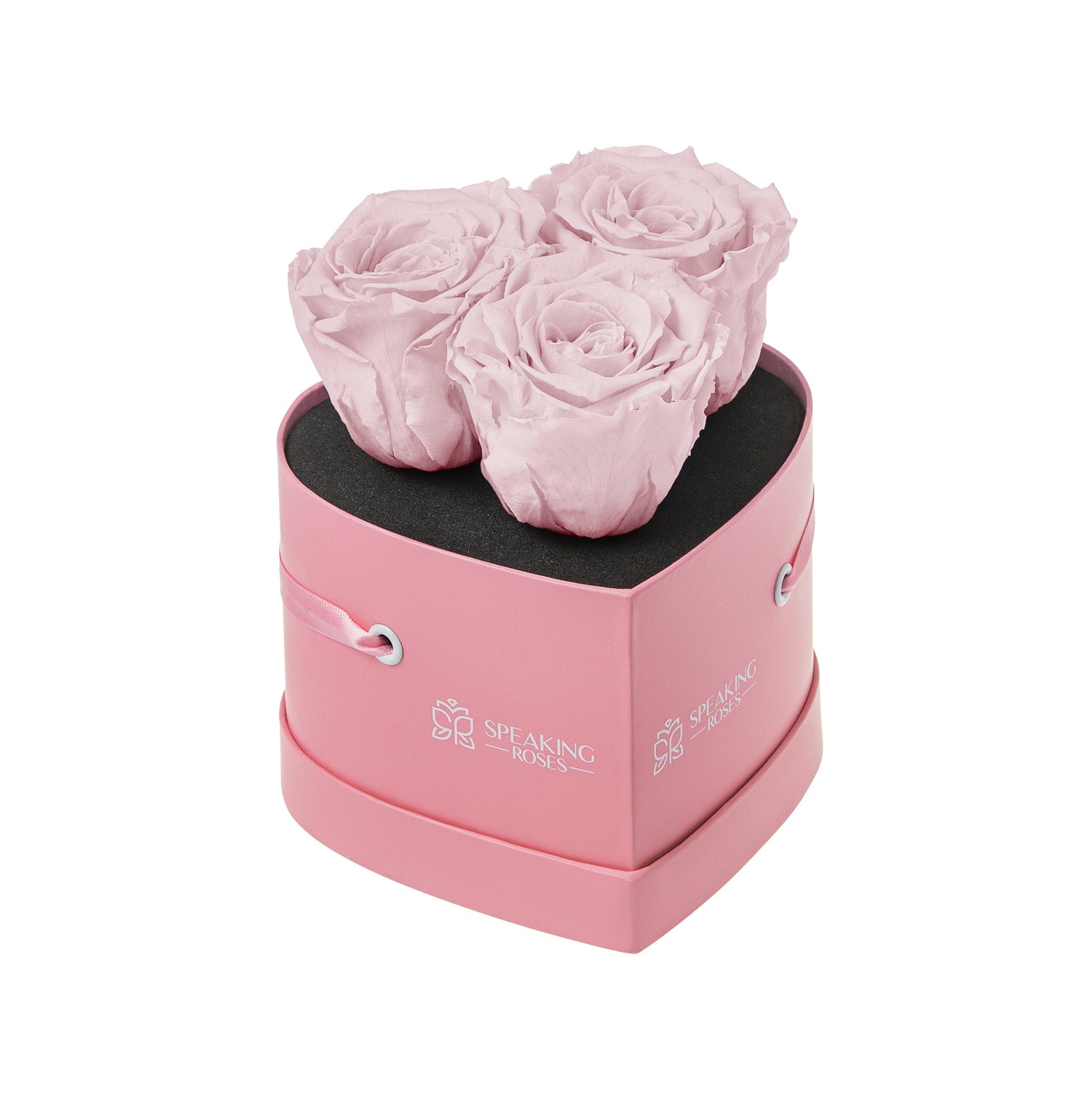 Pink heart-shaped box with three pink roses on a white background