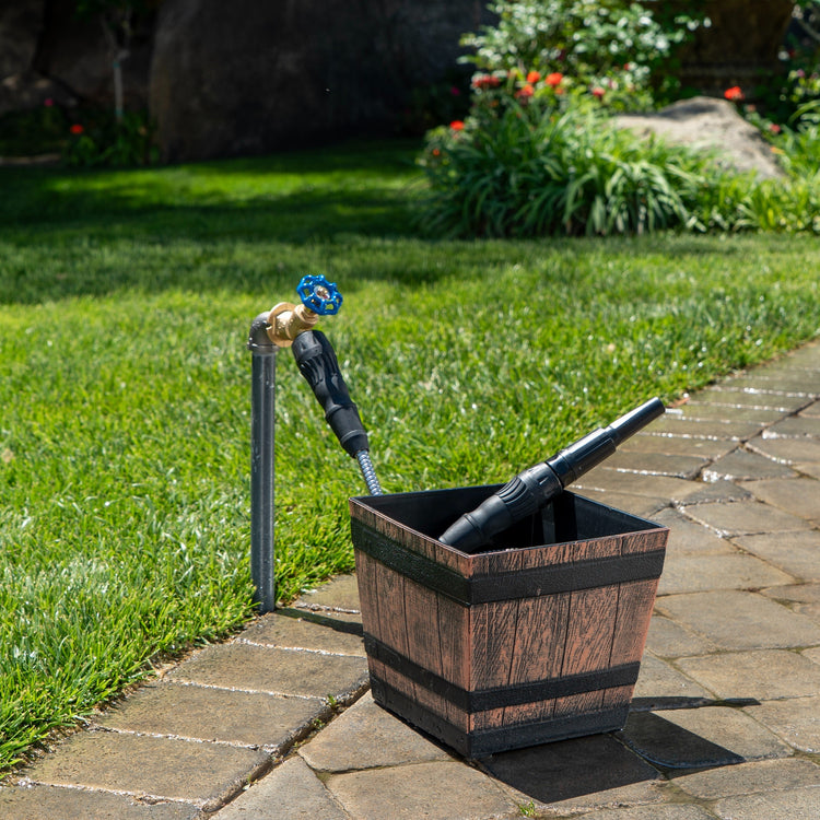 Wooden planter with garden tools on a patio next to grass