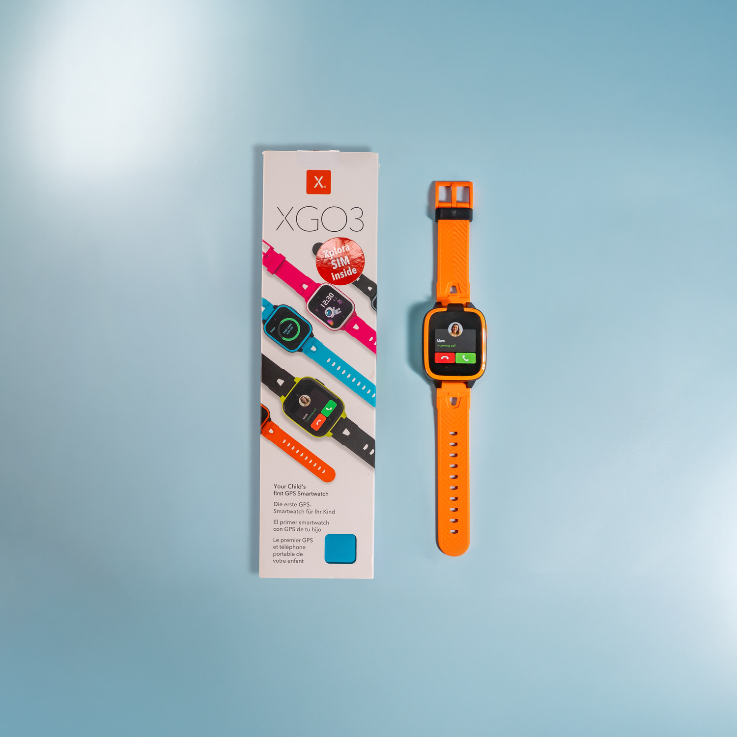Orange smartwatch with packaging on a light blue background