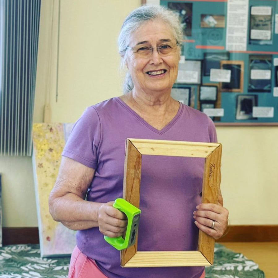 woman holding the hammer fist and a picture frame 