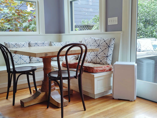 White air purifier on a wooden floor with a blurred background