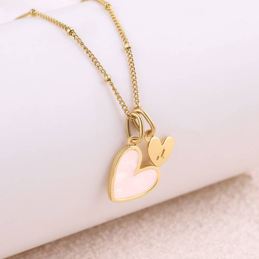 Gold necklace with a heart-shaped pendant on a white background