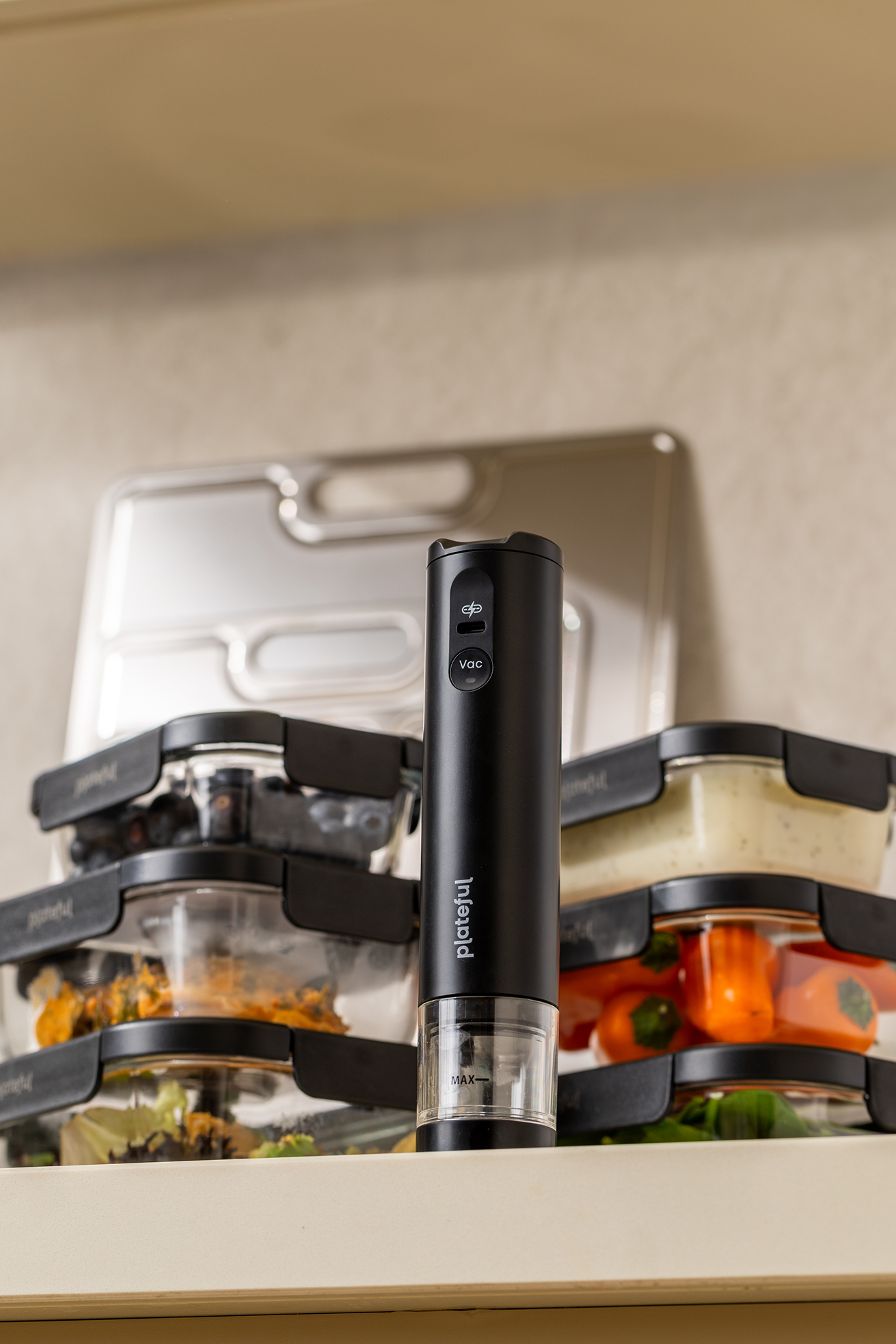 Black kitchen tool on a counter with containers in the background