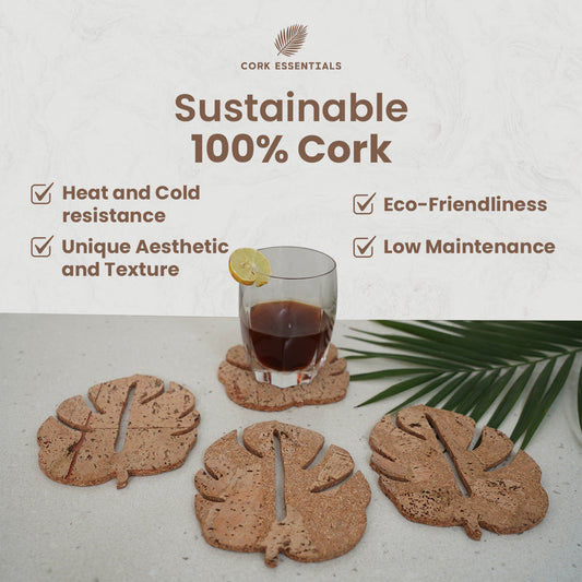 Set of leaf-shaped coasters with a glass of dark liquid on a white background