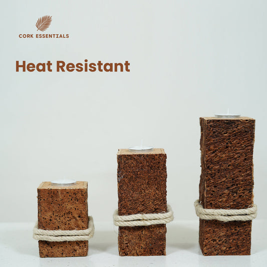 Three square-shaped candle holders made of cork with rope around them on a white background.