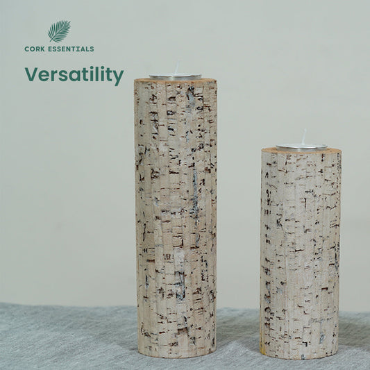 Three cylindrical candles with bark-like texture and a purple flower on a white background