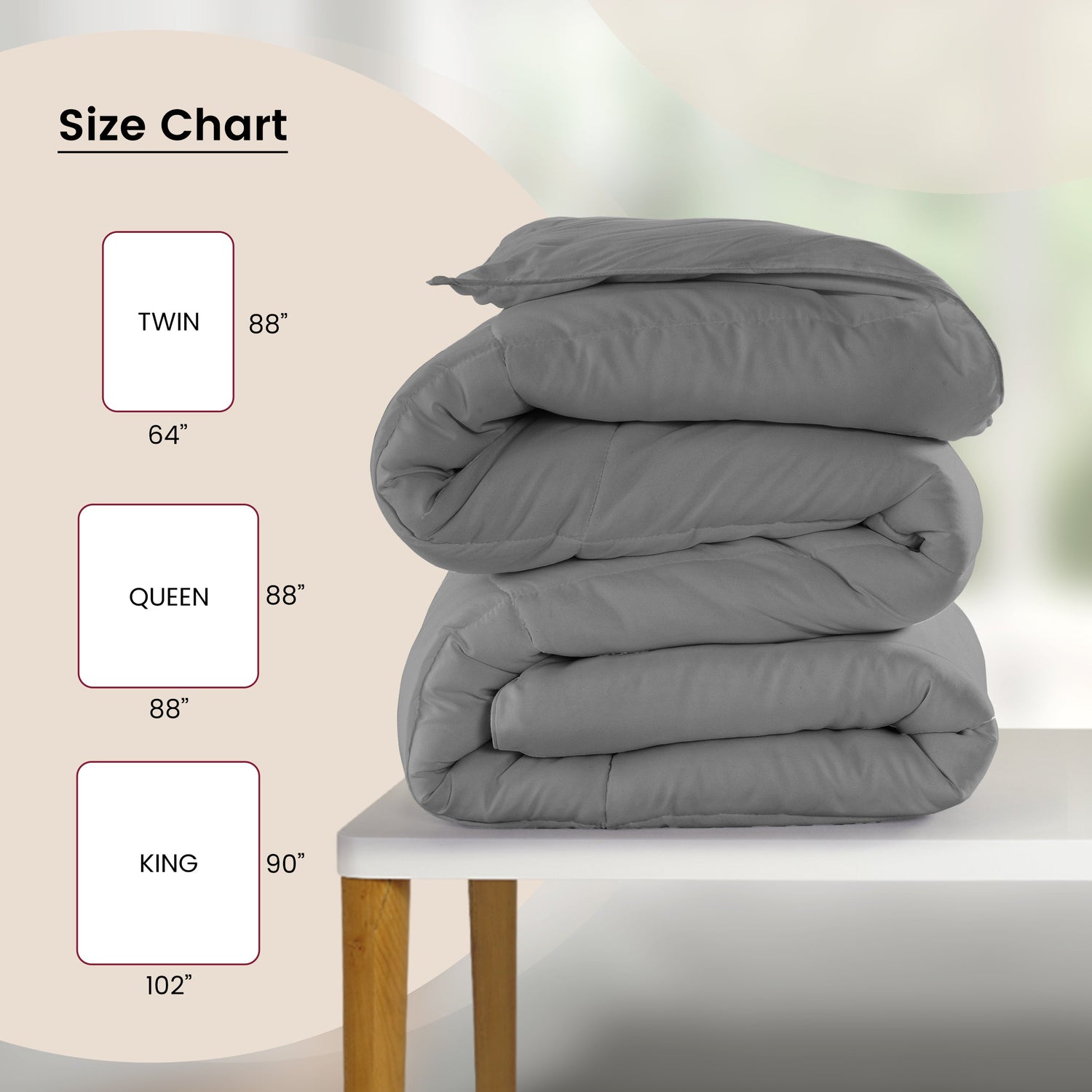 Gray comforter stacked on a table with size chart labels.