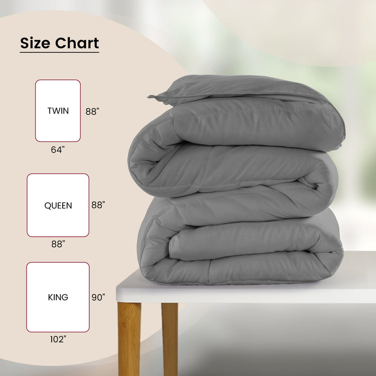 Gray comforter stacked on a table with size chart labels.