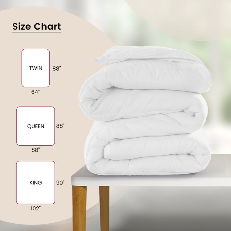 Stack of white comforters on a table with size chart on the left.