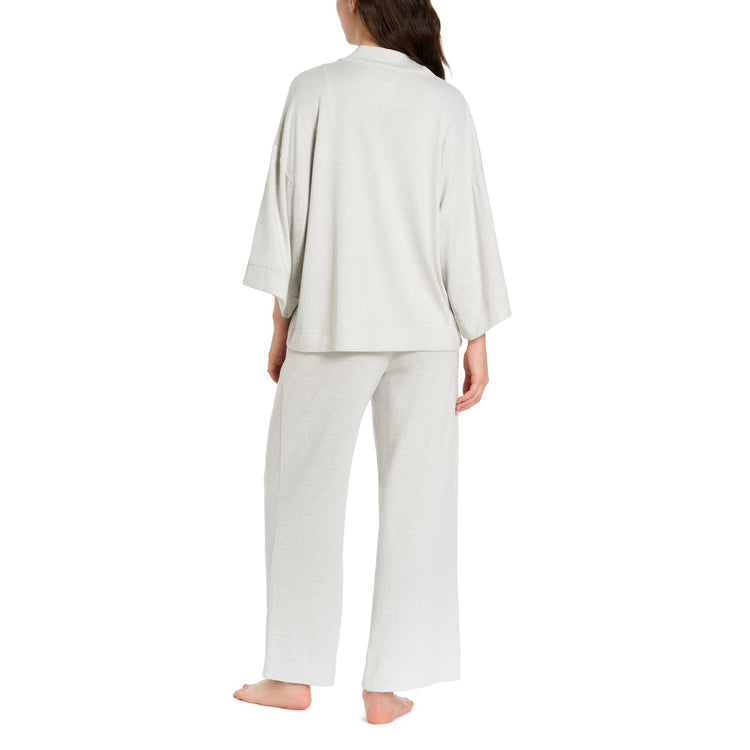 Woman wearing a white pajama set on a white background