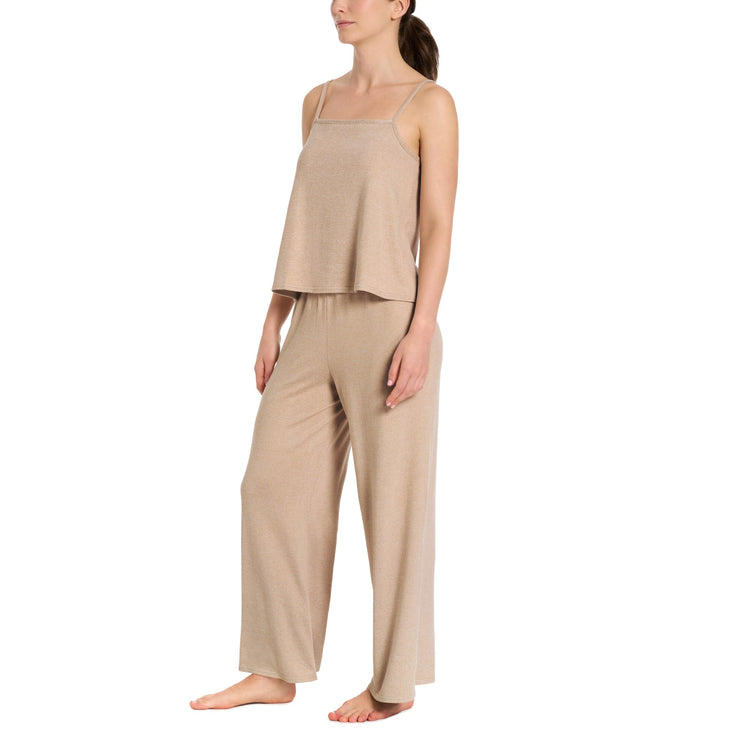 Woman wearing a beige pajama set on a white background