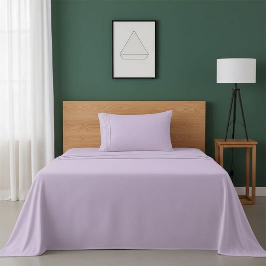 Red bedspread on a wooden bed with a white nightstand and decor items in the background.